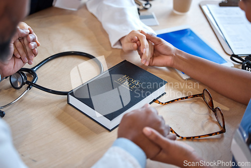Image of Hands, bible and a healthcare team praying for a miracle curing a meeting in a hospital office together. Medical, trust or teamwork with doctors and nurses asking God or Jesus for help in a clinic