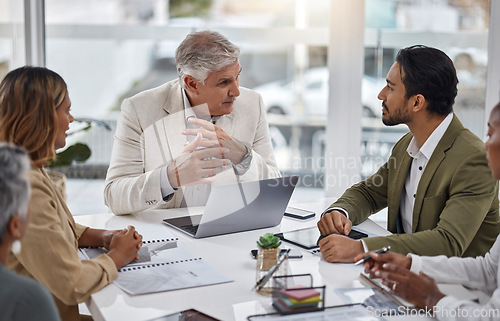 Image of Businessman, laptop and teamwork with documents in meeting for strategy, planning or proposal at office. Corporate man, senior or CEO talking to team in leadership or training staff at the workplace