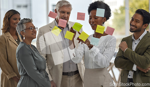 Image of Meeting, presentation and glass with a black woman leading a presentation in a boardroom for company strategy. Teamwork, planning and sticky notes in an office with a female employee talking to staff