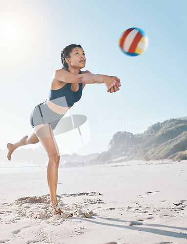 Image of Woman, volleyball and hitting on beach in sports game, practice match or competition in the outdoors. Female person or player in volley or spiking ball up for fitness, point or athletics by the ocean