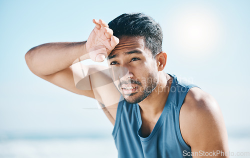 Image of Fitness, sweating and man breathing at the beach after training, running and intense cardio, focus and resting. Face, tired and male runner stop, sweat and breathe during health workout at the sea