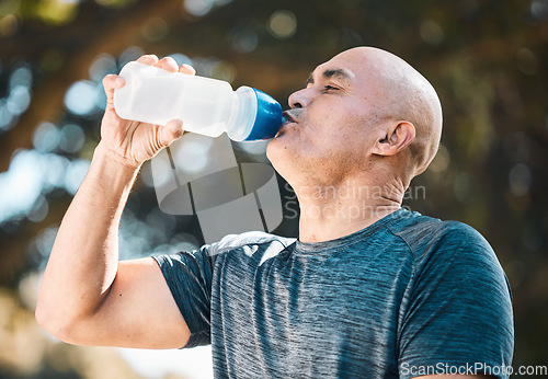 Image of Man, drinking water and hydration in fitness after workout for nutrition, sustainability or thirst in nature. Tired and thirsty male person with healthy beverage for running, exercise or training