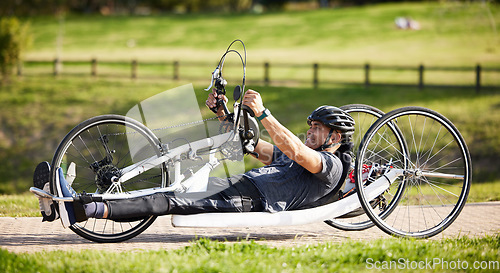 Image of Cycling, fitness and health with man and handcycle in nature for training, sports and challenge. Exercise, workout and wellness with person with a disability in park for cardio and bicycle marathon