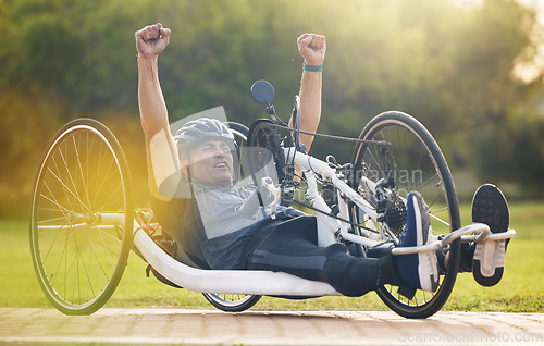 Image of Cycling, winning and happy man with disability, competition training with success and exercise champion on bike. Happiness, workout and celebration, person on recumbent bicycle and winner of race.