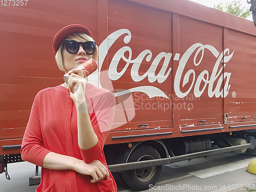 Image of Kyiv, Ukraine - July 6, 2017 Beautiful fashionable woman with model release drinking Coca-Cola soda