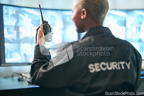 Image of Back, security and radio surveillance with a woman officer in a control to monitor criminal activity. Safety, dispatch and cctv with a female guard sitting in her office using a walkie talkie