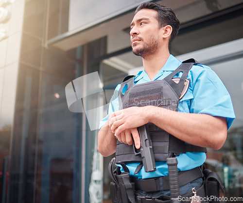 Image of Security guard, safety officer and bodyguard man with a gun outdoor to patrol, safeguard and watch. Serious asian male at a building or property for crime prevention or armed response with a weapon
