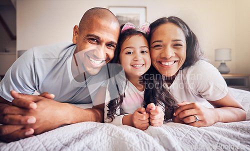 Image of Family, portrait and relax on a bed at home with a smile and comfort for quality time. Man, woman or hispanic parents and a girl kid together in the bedroom for morning bonding with love and care