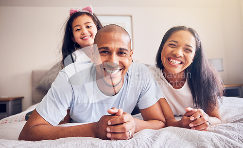 Image of Portrait, happy and a family relax on a bed at home while laughing and playing for quality time. Man, woman or hispanic parents and kid together in the bedroom for morning bonding with love and care