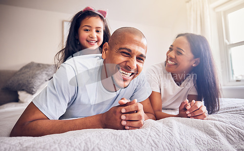 Image of Mother, father and child laughing on a bed in a family home while happy and playing for quality time. Man, woman or parents and girl kid together in the bedroom for morning bonding with love and care