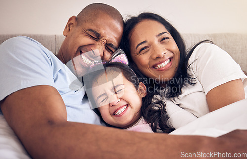 Image of Family, hug and happy on a bed at home with a smile, comfort and security for quality time. Man, woman or latino parents and a girl kid together in the bedroom for morning bonding with love and care