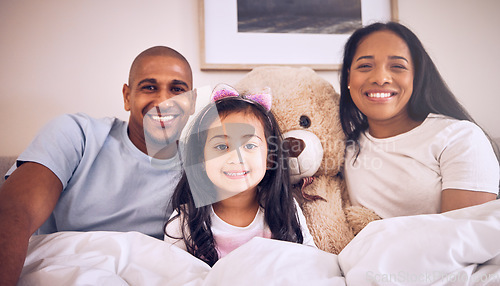 Image of Family, morning and happy portrait on a bed at home with a smile, teddy bear and comfort for quality time. Man, woman or parents and a girl kid together in the bedroom for bonding with love and care