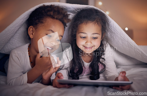 Image of Happy, night and children with a tablet in bed for cartoon, movie or streaming a show. Smile, blanket and girl kids with technology in the bedroom for the internet, education or online fun together