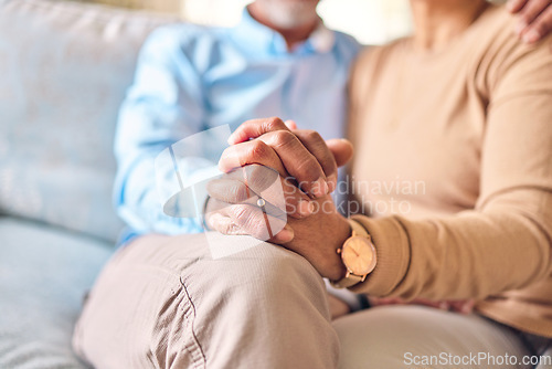 Image of Love, support and a senior couple holding hands while sitting on a sofa in the living room of their home during retirement. Trust, relax or affection with an elderly man and woman bonding together