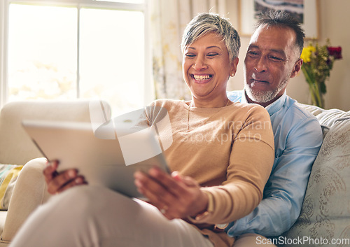 Image of Happy, streaming and a couple with a tablet on the sofa for communication, social media or online chat. Smile, house and a senior man and woman with a movie on technology on the couch and laughing