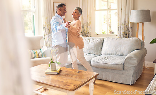 Image of Love, retirement and dance with a senior couple in the living room of their home together for bonding. Marriage, romance or bonding with an elderly man and woman dancing in the lounge of their house