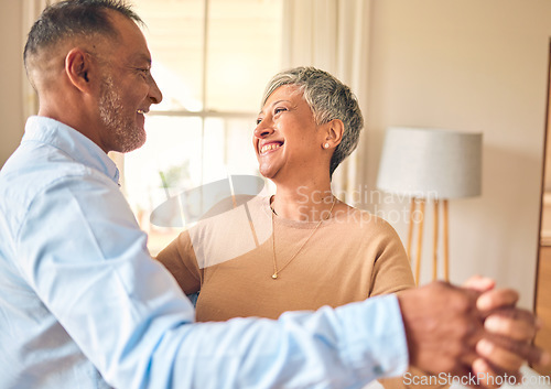 Image of Love, marriage and dance with a senior couple in the living room of their home together for bonding. Romance, retirement or bonding with an elderly man and woman dancing in the lounge of their house