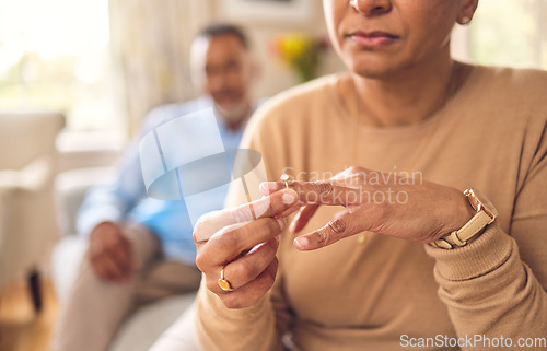 Image of Senior woman, hands and ring in divorce, fight or conflict from disagreement or argument on sofa at home. Elderly couple in depression, infertility or cheating, mistake or toxic marriage in the house