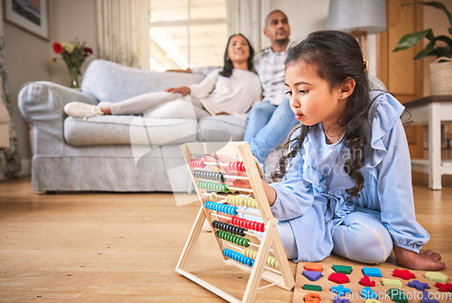 Image of Child, family home and learning with abacus on the floor or mom, dad and girl relax in living room with a game. Kid, development in math and toys for education and couple together on couch in house