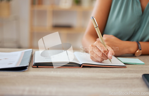 Image of Hand, pen and writing in a notebook with a business woman sitting at a desk in her office for planning. Agenda, schedule and appointment with a female employee making a note in her journal or diary