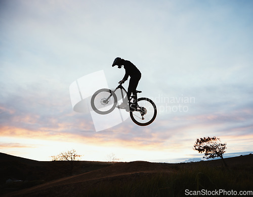 Image of Jump, motorcycle and sunset with sport or sky and adventure in nature with risk or speed. Freedom, action and hill with silhouette with dirt bike in outdoor with training or race or power, danger.