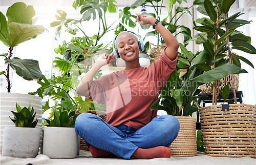 Image of Music, dance or freedom with a black woman in her home by plants while listening to an audio playlist. Headphones, flare and subscription service with a carefree young person streaming in a house