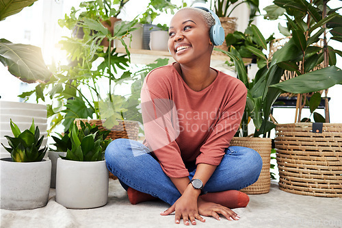 Image of Music, relax and thinking with a black woman in her home by plants while streaming an audio playlist. Headphones, radio and subscription service with a happy young female person in her house