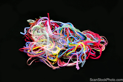 Image of Ball of multicolored tangled threads for needlework on black bac