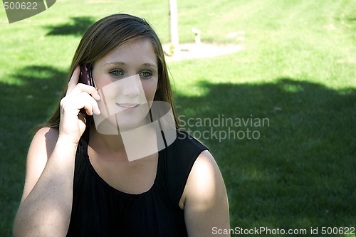 Image of Beautiful Girl in the Park in a Black Dress Talking on the Phone