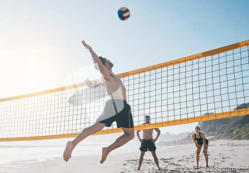 Image of Man, jump and volleyball in air on beach by net in sports match, game or competition. Body of male person jumping for ball in volley or spike in healthy fitness, energy or exercise by the ocean coast