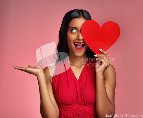 Image of Woman, happy surprise and heart, advertising mockup in red dress and promotion of love on pink background. Valentines Day marketing, female model in lipstick and wow expression for branding in studio