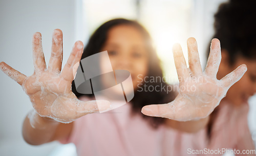 Image of Girl kid, washing hands and palm in closeup with foam, cleaning and learning hygiene in family home. Young child, soap and mother for bacteria, germs and stop virus for care, bond and love in house