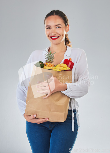 Image of Portrait, smile and woman with grocery bag, fruit and sales in studio isolated on a white background. Shopping, food and happy customer with organic vegetables for nutrition, healthy diet or wellness