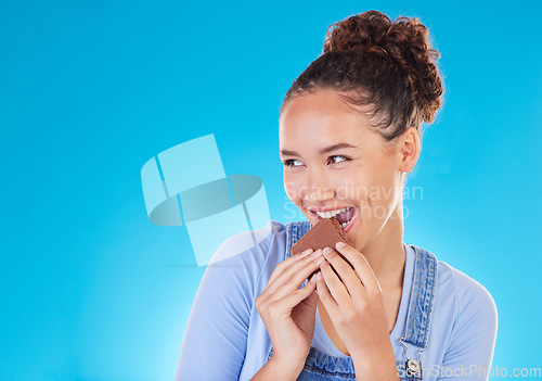 Image of Chocolate, dessert and space with woman in studio for fast food, diet and nutrition. Happy, cacao and sugar with person eating on blue background for candy, health and hungry with mockup