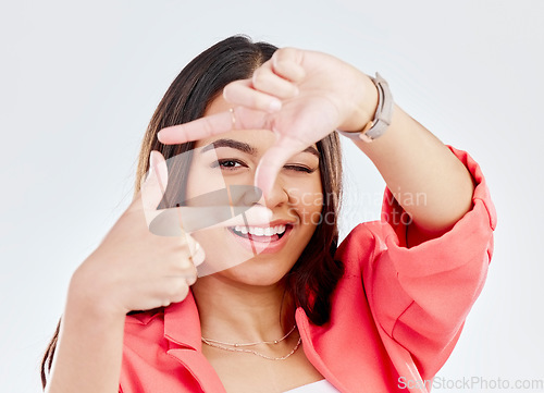 Image of Happy, portrait of a woman with hand frame and against a white background. Social media or creativity, face or smile and female person pose with gesture for perfect photography in studio backdrop