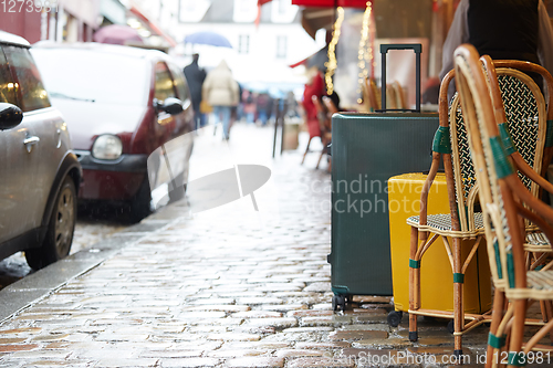 Image of Luggage bag on the city street ready to pick by airport transfer taxi car.