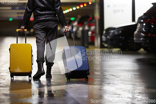 Image of Back view of walking woman with two suitcase. Beautiful girl in motion. Backside view of traveler with baggage