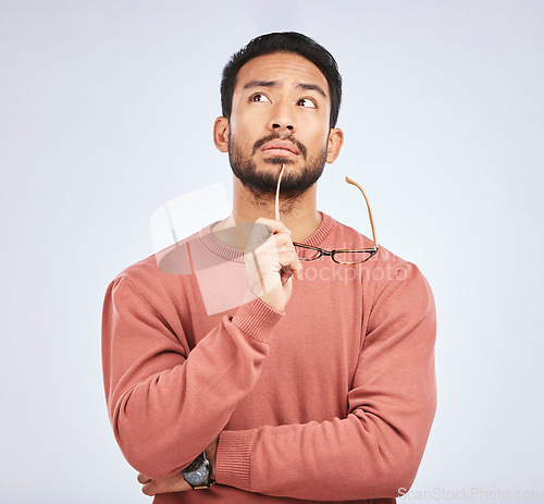 Image of Decision, thinking and asian man in studio with glasses, questions and brainstorming on grey background. Why, idea and male person with emoji, body language or choice gesture, puzzled or solution