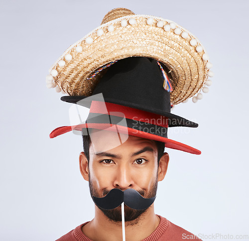 Image of Photo booth, hat and portrait of man with mustache for comic, humor and funny joke in studio. Happy, Mexican party accessory and silly face of male person on gray background with sombrero for comedy