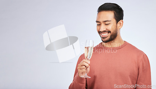 Image of Champagne, celebration and asian man with glass in studio for success, milestone or victory on grey background. Wine, happy and male winner celebrating promotion, announcement or competition giveaway