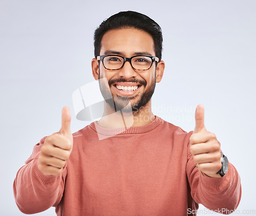Image of Thumbs up, portrait and man with glasses for success in studio, white background and winning news. Happy asian male model, ok emoji and like of feedback, review and vote yes in agreement of promotion