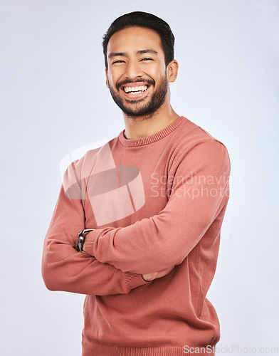 Image of Portrait, happy or Asian man laughing with arms crossed or smile in studio in casual fashion or clothes. Relax, confidence or handsome male person smiling on white background with pride, humor or joy