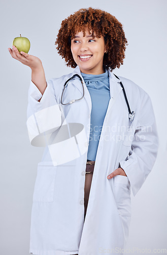 Image of Doctor, woman and smile with apple in studio, white background and wellness. Happy medical employee, female nutritionist and holding green fruits for vitamin c nutrition, healthy food and vegan diet