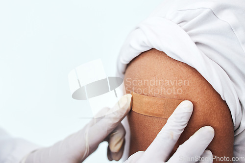 Image of Healthcare, arm and closeup with plaster for vaccine, hands of doctor for protection and virus safety in clinic. Consultation, patient and medical professional in hospital for vaccination medicine.