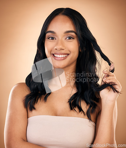 Image of Portrait, hair and aesthetic with a model woman in studio on a brown background for shampoo treatment. Beauty, salon and smile with a confident young person looking natural after cosmetic haircare