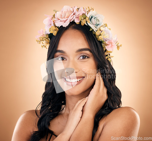 Image of Portrait, smile and flower crown with a model woman in studio on a brown background for shampoo treatment. Beauty, salon and hair with a happy young person looking confident about natural cosmetics