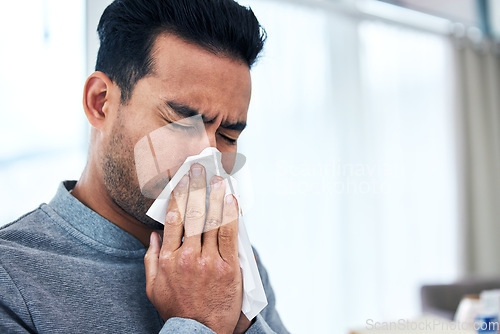 Image of Blowing nose, sick and man with tissue for allergies, hayfever and sinus problem at home. Healthcare, flu symptoms and male person sneeze with handkerchief for sinusitis infection, virus and illness