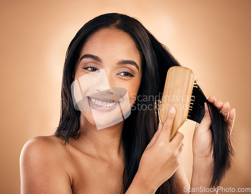 Image of Hair care, brush and happy woman with beauty isolated on a brown background in studio. Salon, smile and model with a wood grooming product for natural aesthetic, hairdresser or hairstyle for wellness