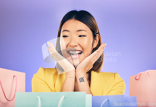 Image of Happy, face and woman with shopping bag from a sale, promotion or customer with deal on retail clothing. Surprise, face and Asian model with smile emoji or crazy discount on luxury product or store