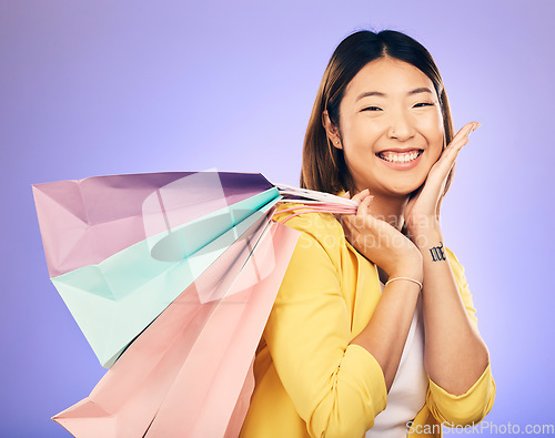 Image of Happy, portrait and woman with shopping bag, retail and commerce with fashion sale on purple background. Discount at boutique shop, Asian female customer and market with store promotion in studio